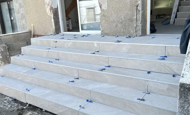 Nous avons ensuite procédé à la pose de carrelage grand format, en utilisant un système de nivellement pour garantir un alignement précis et des finitions impeccables sur chaque marche.