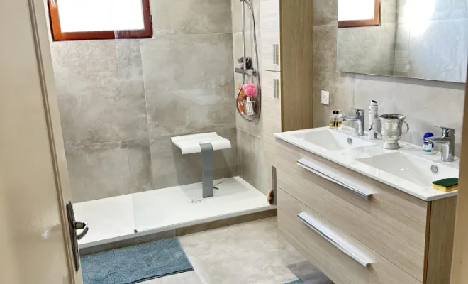 La salle de bain a ensuite été habillée avec un carrelage grand format, apportant une touche contemporaine et lumineuse à l’espace. Une douche à l’italienne avec paroi vitrée a été installée afin d’optimiser le confort et l’esthétique de la pièce