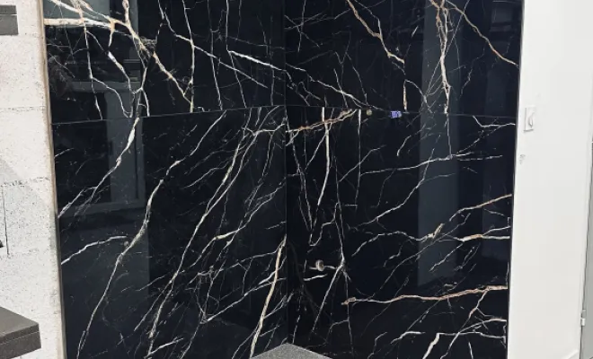 Des carreaux 120 × 120 cm effet marbre noir avec veines dorées ont ensuite été posés avec une grande précision afin d’obtenir un alignement harmonieux et des finitions impeccables.